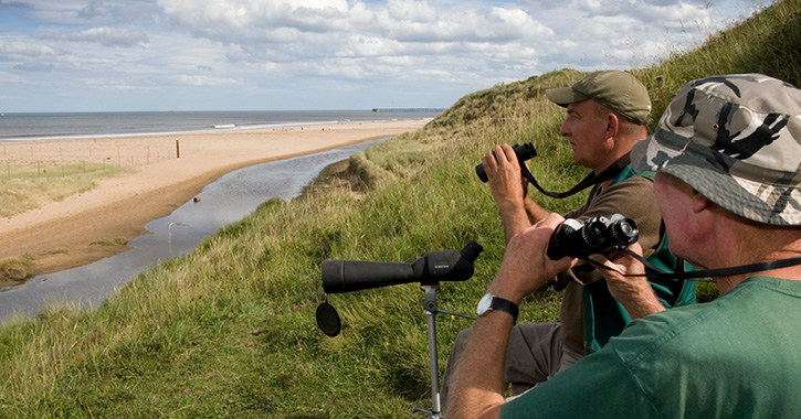 two men with binoculars birdwatching on the Durham Heritage Coast